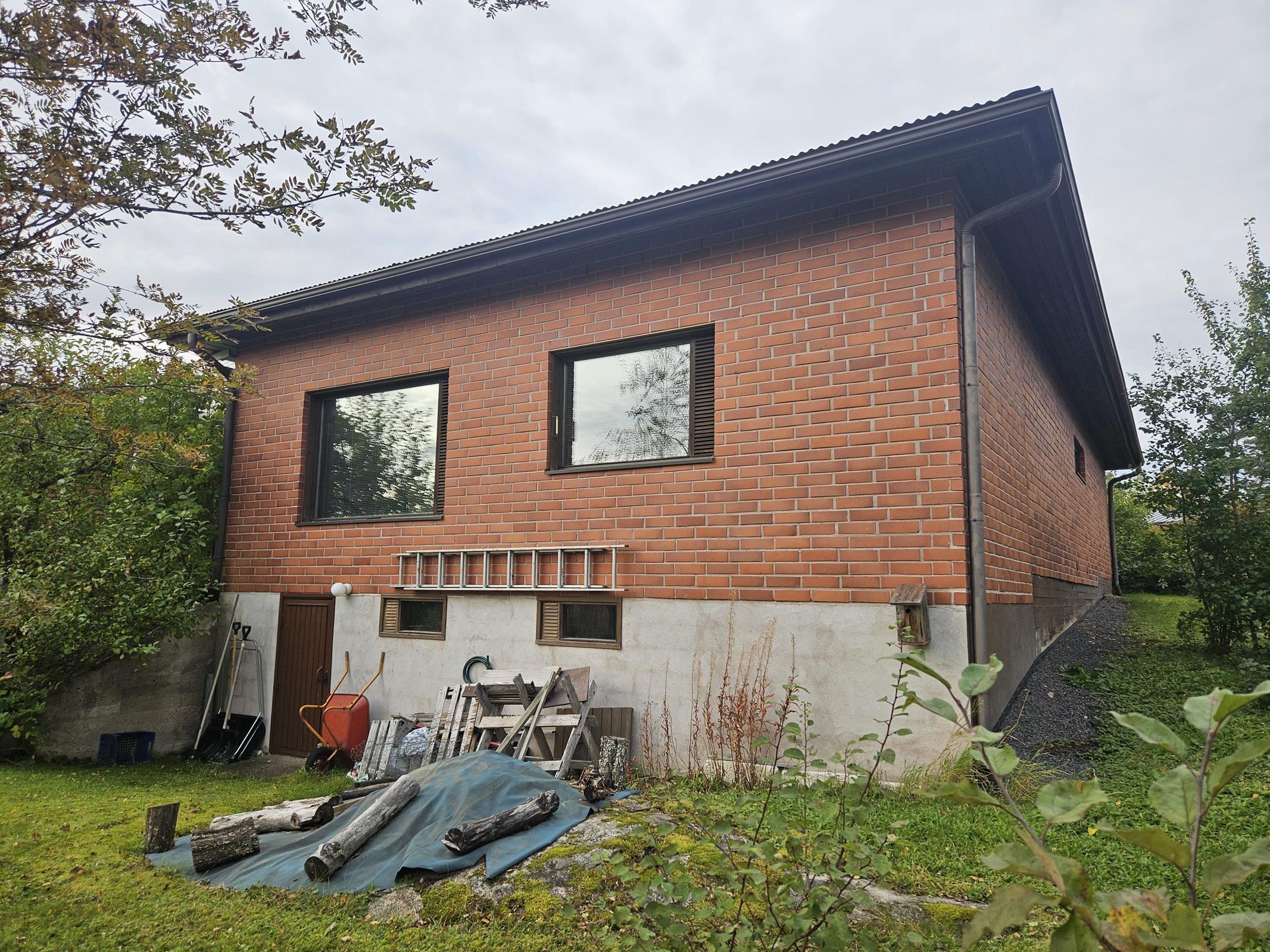 talo alapihalta, etualalla laajennusosa ja sen all