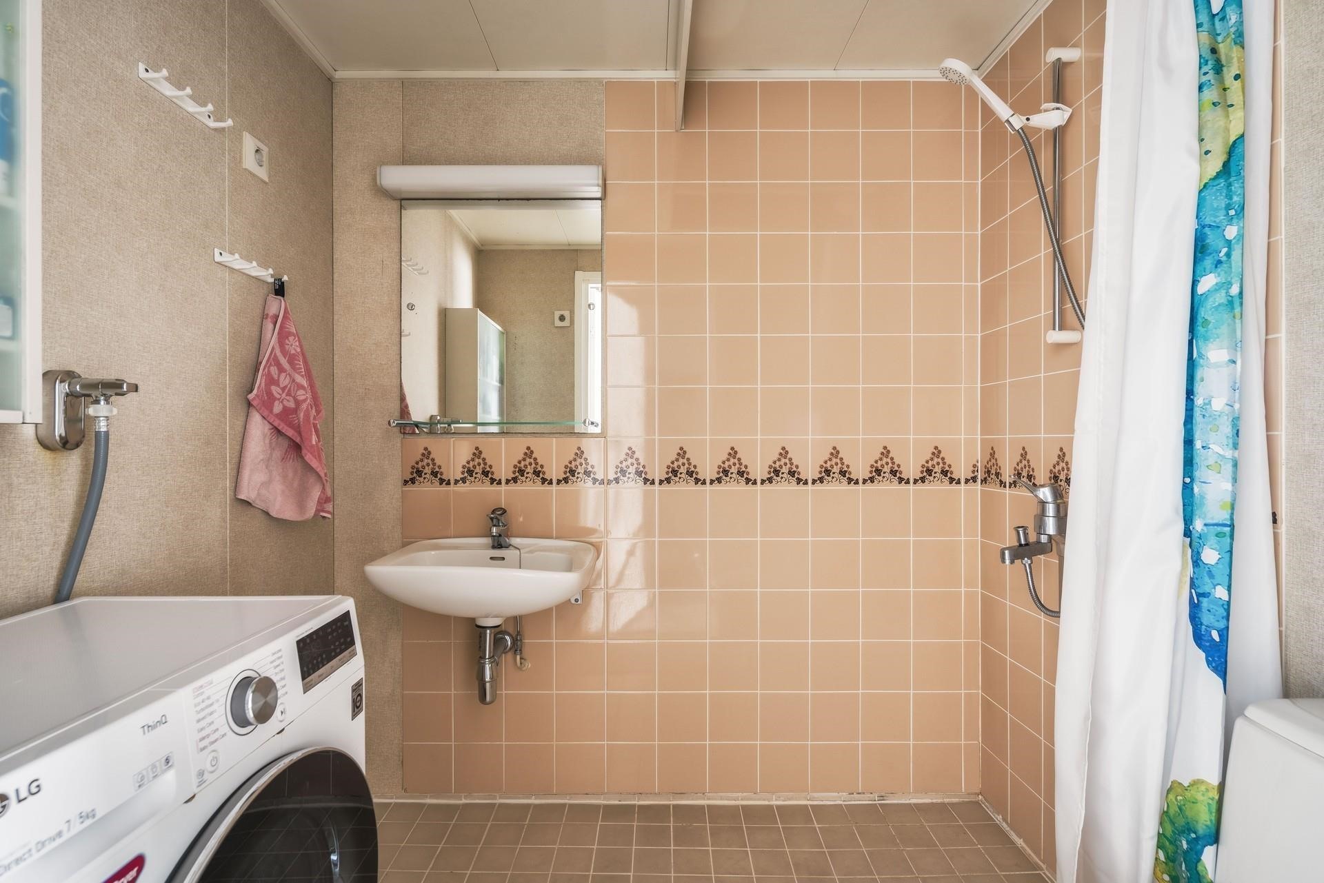 Kylpyhuoneessa on valmiina pyykinpesukone.