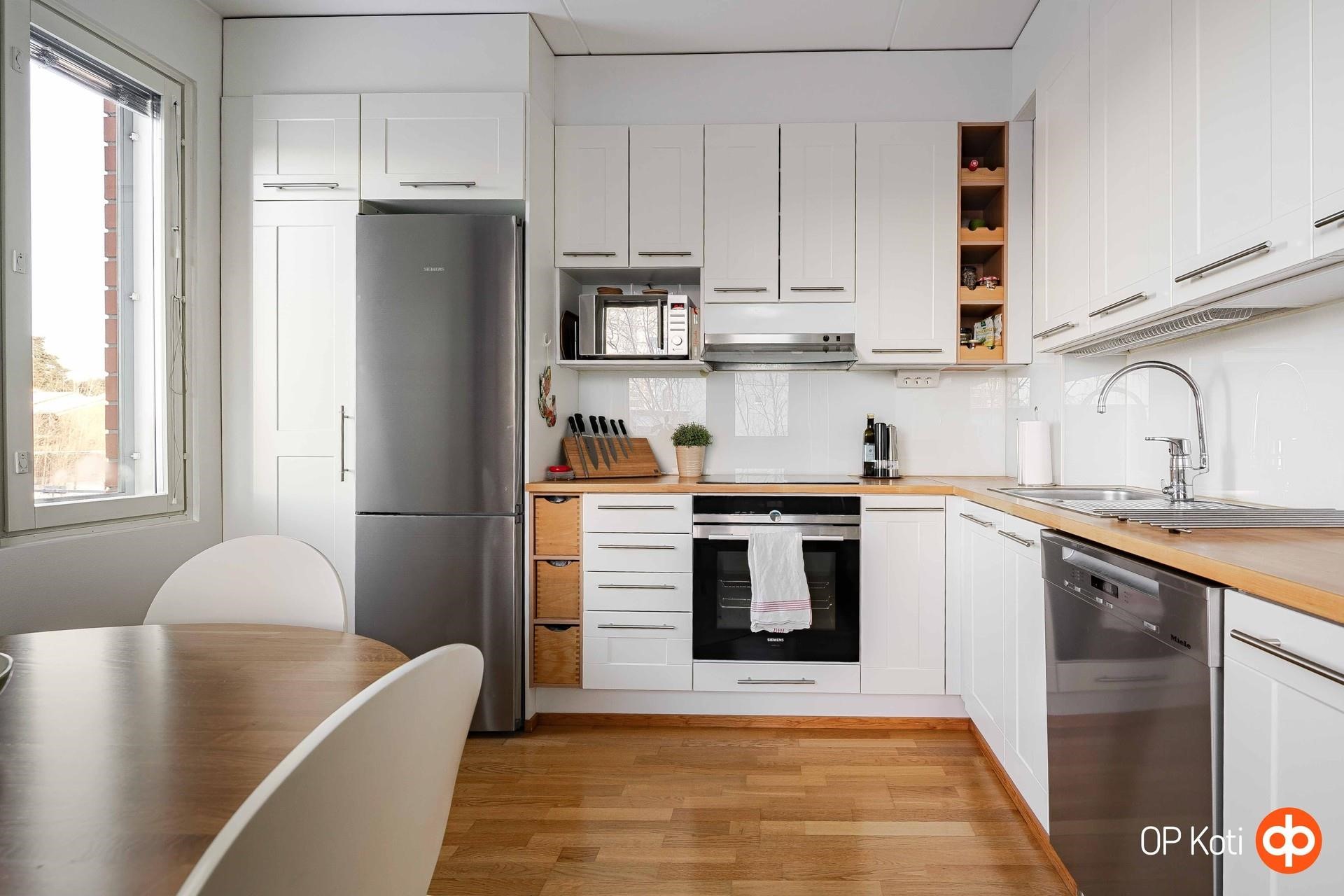 Keittiössä työtilaa ja laadukkaat kodinkoneet.